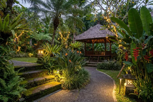 Warm garden lighting illuminating tropical plants at a Bali villa at night